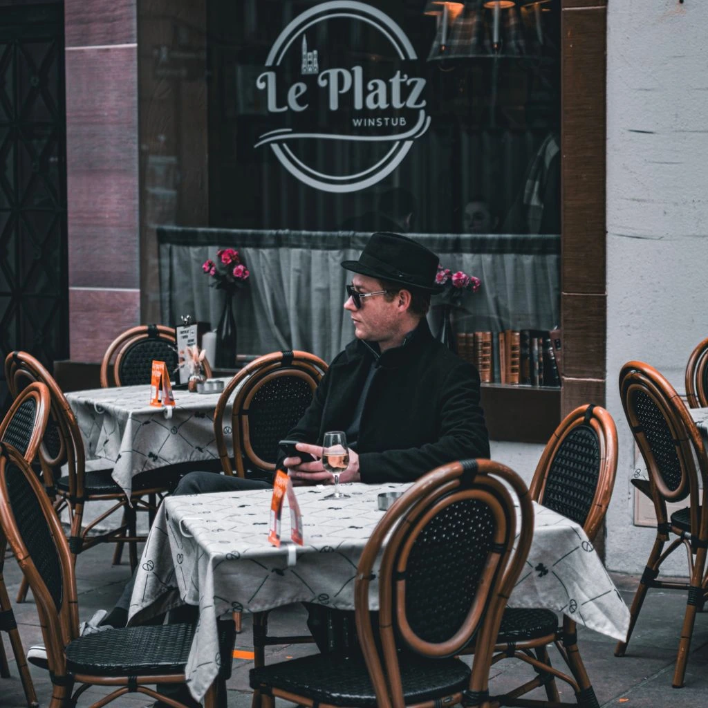 Restaurant menu posters taped to a brick wall above a bistro table